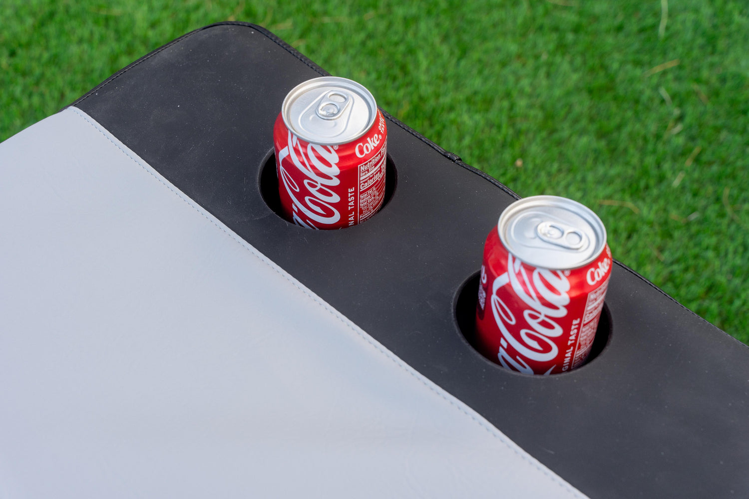 Cooler seat pad with integrated silicone cup holders molded into lid cushion